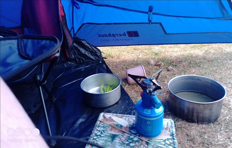 Camping Gaz stove, pan and cups in the tent porch
