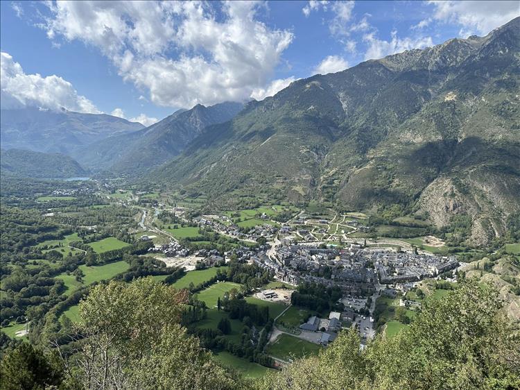 Looking down from the steep mountains we see a town in the flat valley below