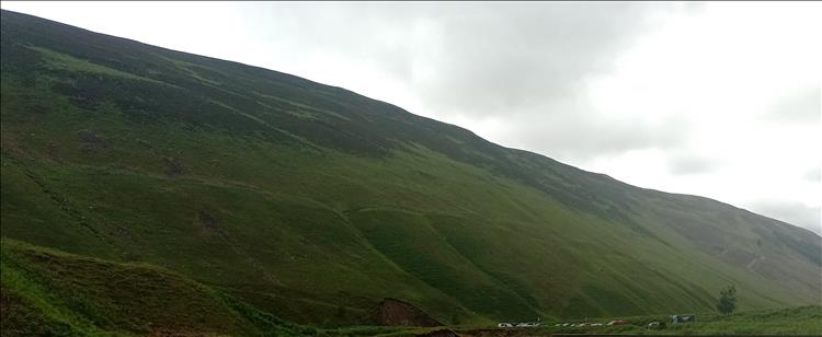 A thick solid mountain covered in grasses and moss, ominous and overbearing