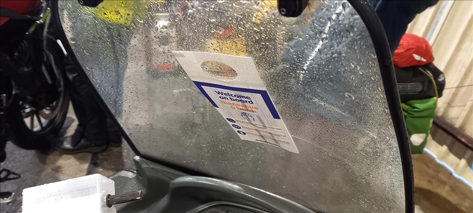 A boarding pass, a small rectangular card, taped onto the screen of Bogger's scooter