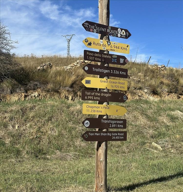 A pole with "Silent Route" at the top and other pointers to many famous mountain passes
