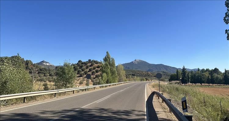 Road with the hills growing into the distance and the dry grass mixing with bushes