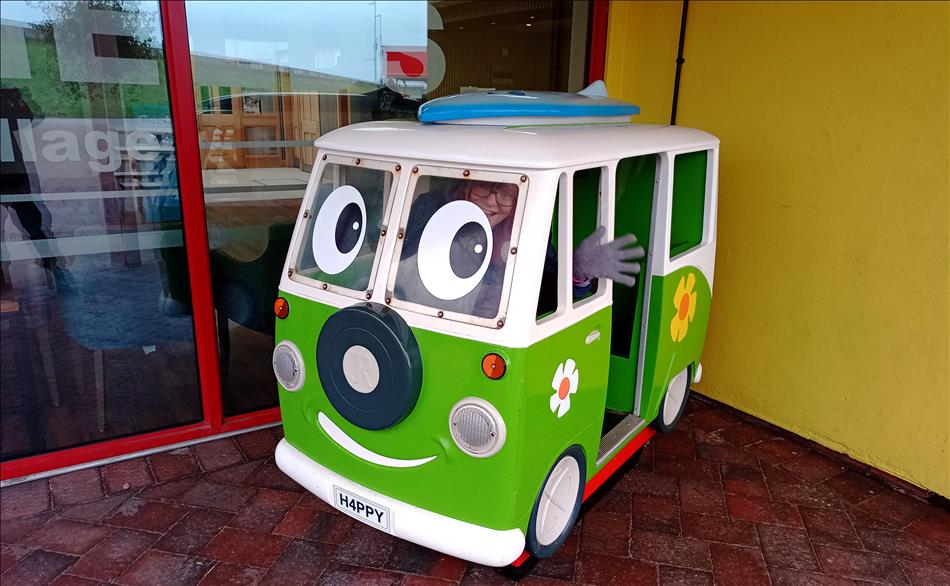 Sharon waves out the window of the tiny little toy van