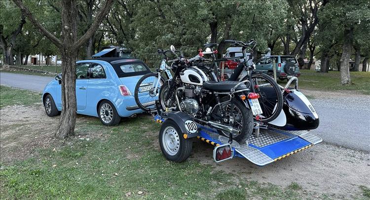 A sidecar unit and a bicly seem to overload a trailer behind the small fiat 500