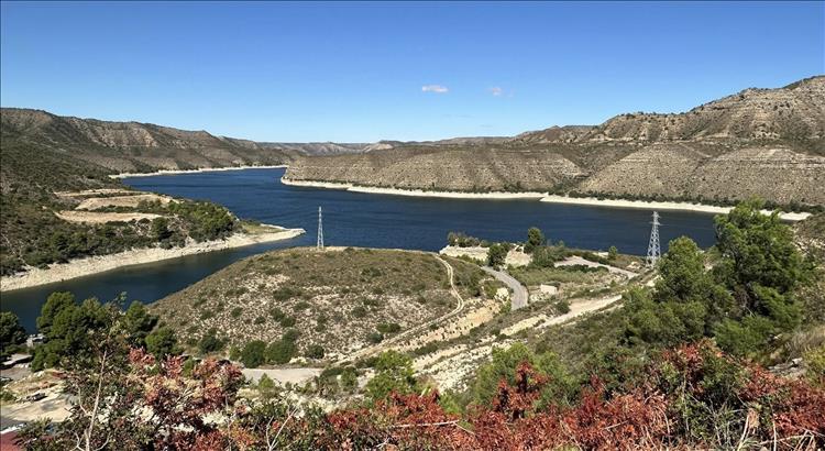 The big river getting bigger between more arid mountainsides and hardy bush