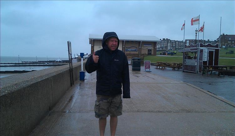 Ren's friend Ian stood in waterproof jacket and heavy rain beside the coast