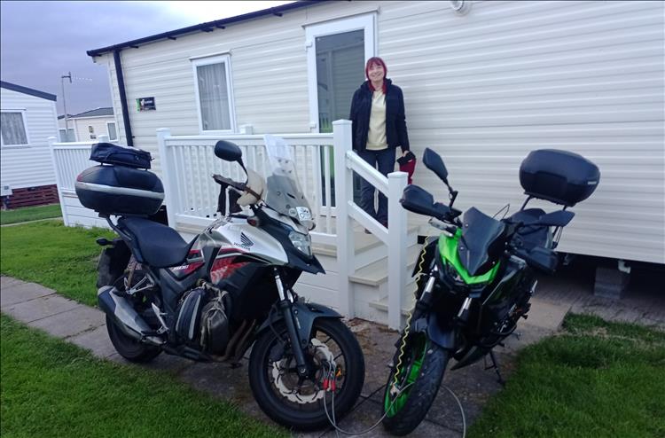 Both bikes are on a small flagged area outside the door of the static and locked together
