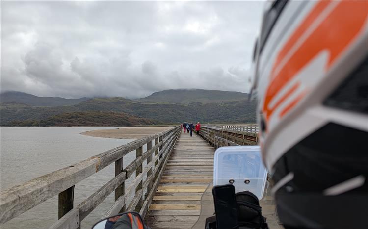 looking over Ren's shoulder on the bike we see the path and pedestrians on the bridge