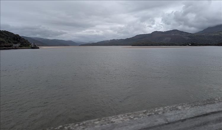 Looking from the bridge we see the broad estuary with sandbanks and mountains against dramatic skies