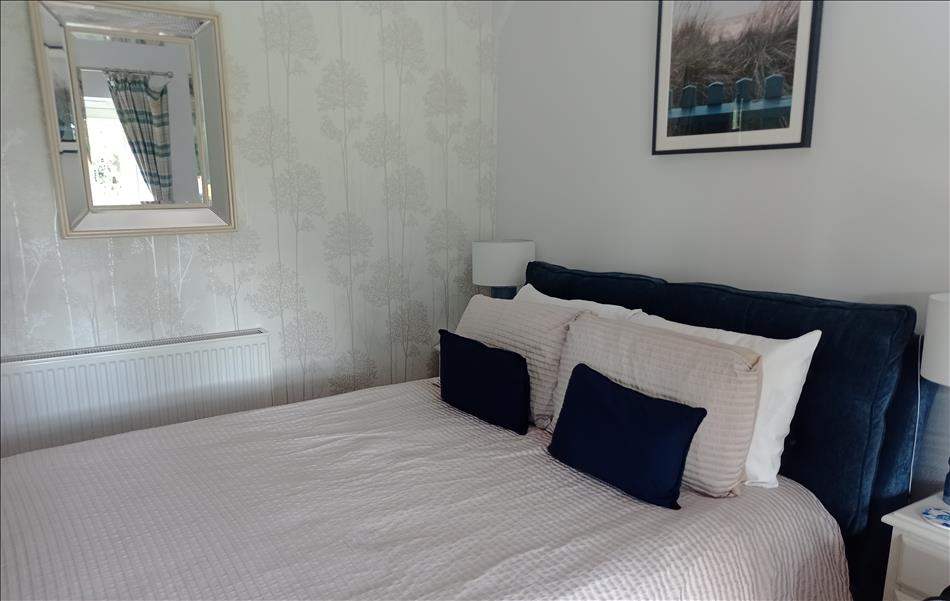 A smart simple room with a freshly made double bed