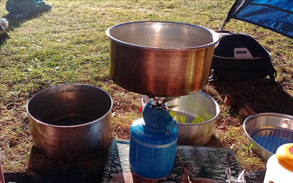 THe blue campingaz canister with a burner stove atop with a pan at a campsite