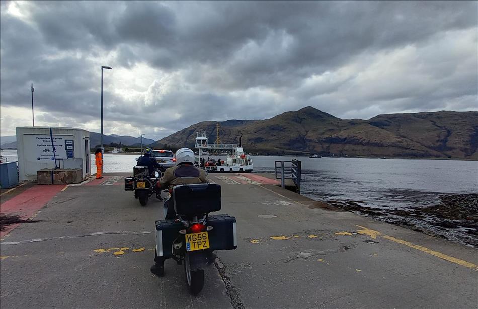 A few bikes and cars loading the Corran ferry in the rugged highlands and darkening skies