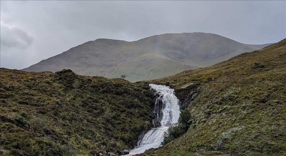 A river runs down the rocks amid the Highlad scenery