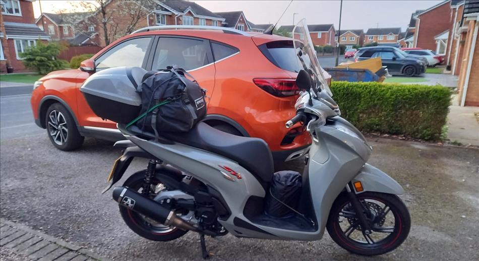 Honda SH350 with top box, bag on the back seat and on a driveway in a housing estate