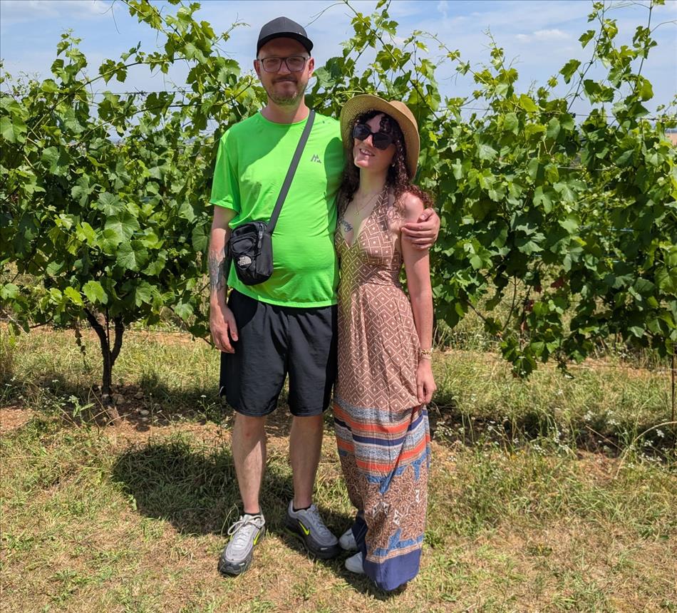 Stan and Megan in a field filled with grape vines