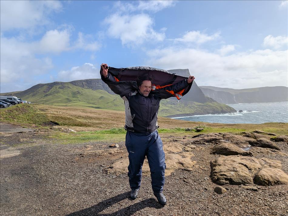 Ren pulls his waterprooj jacket over his head to form a sail to catch the wind