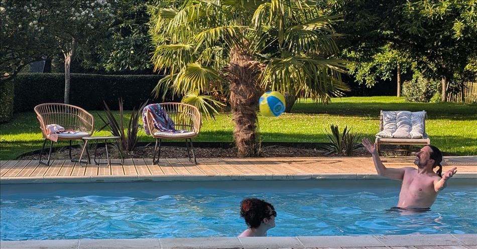 Ren in the pool with a ball flying towards him but his eyes are squinting