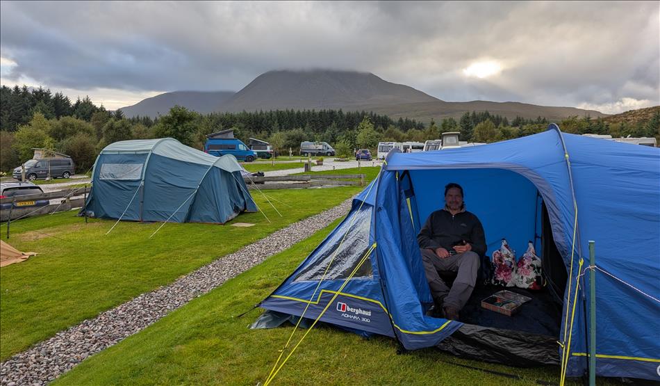 Ren sat on the camping chair in the porch of the tent with the dramatic Skye scenery behind