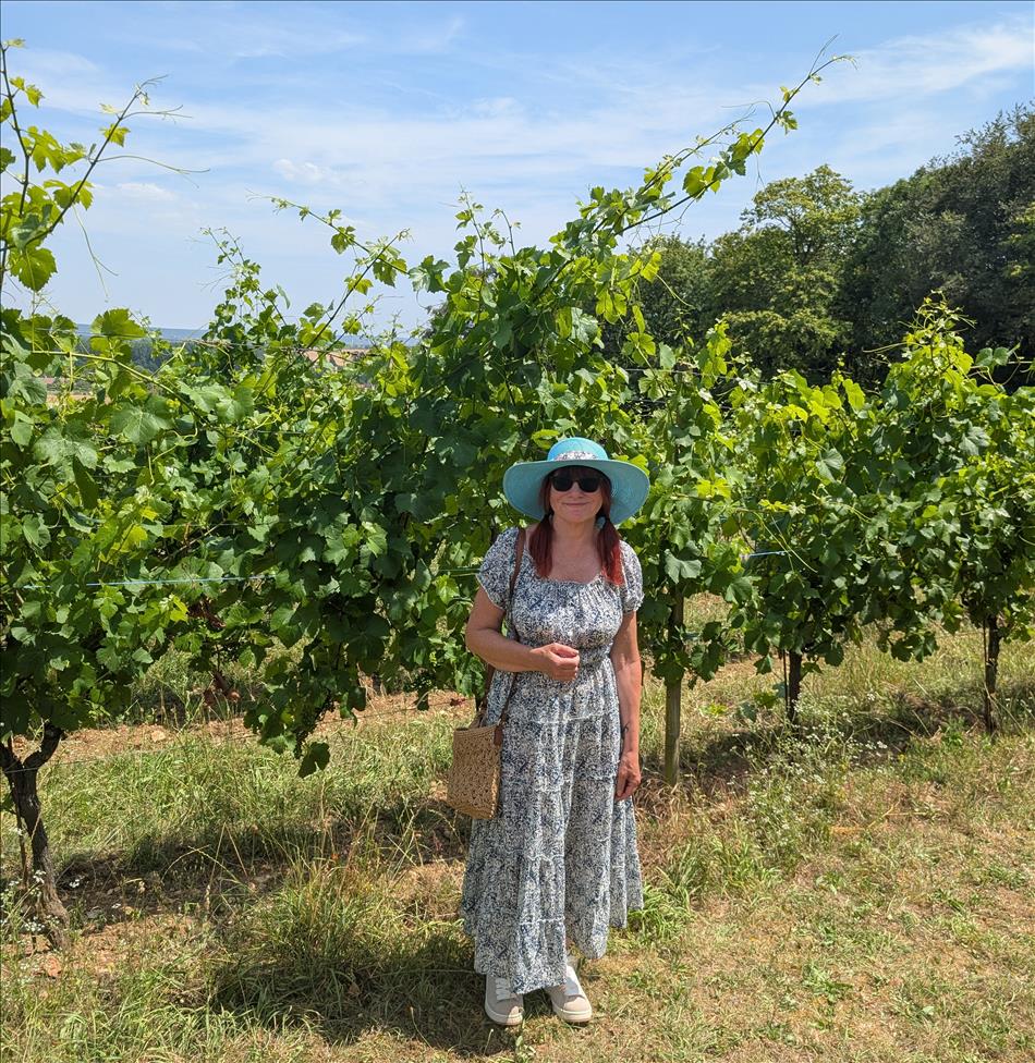 Sharon in summer dress and hat amid the grapvines