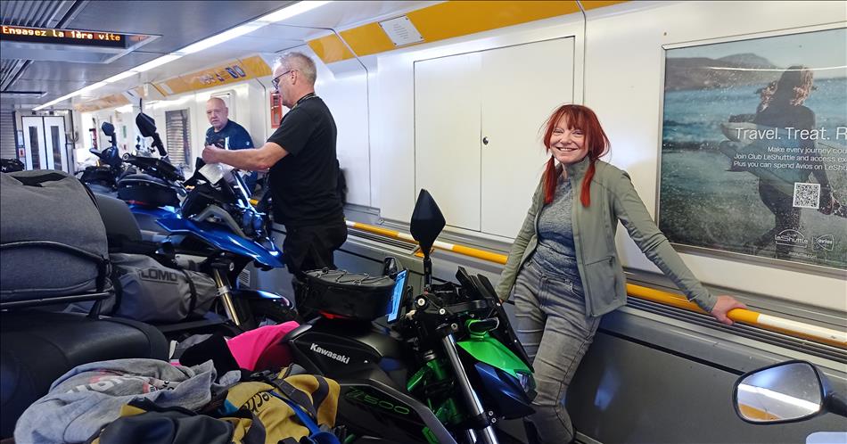Sharon smiles at the camera in the cramped carriage filled with motorcycles in Le Shuttle