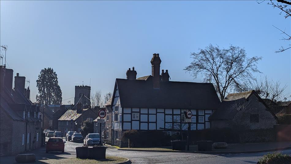 Clear blue skies over timber framed houses and old terraces, we can see the church tower too