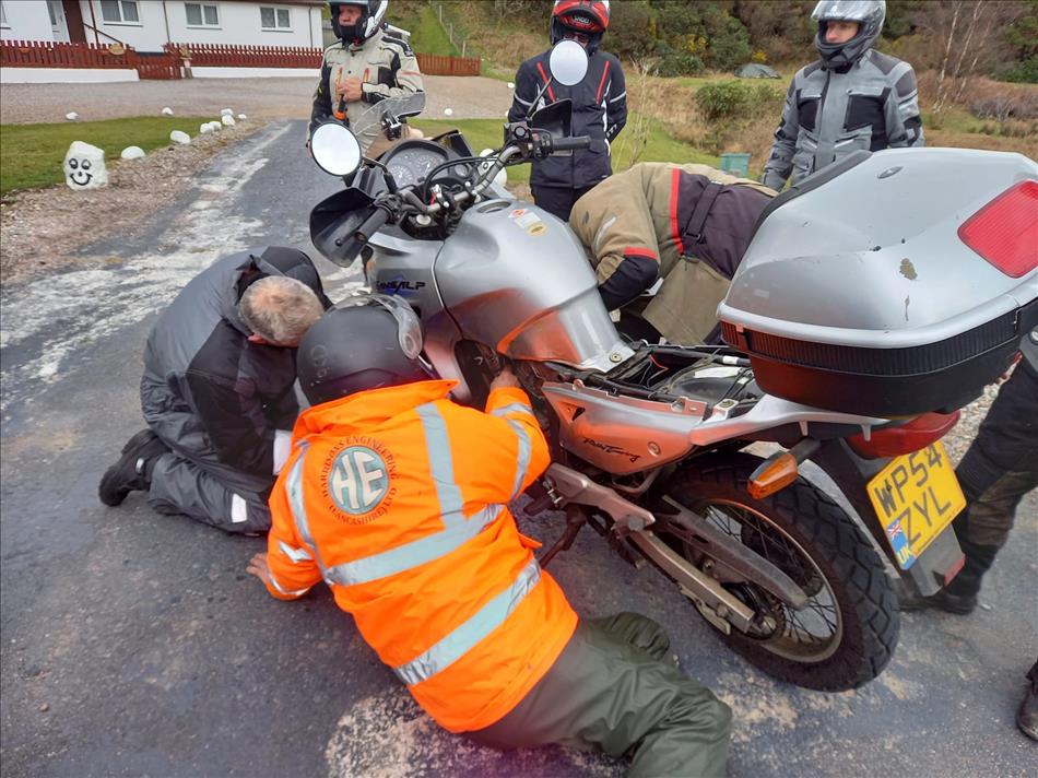 Several riders are working on the motorcycle
