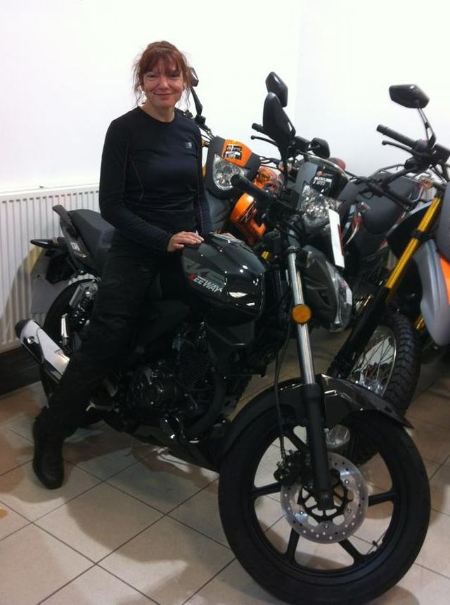 Sharon sits smiling on her new Keeway RKS125 in the shops