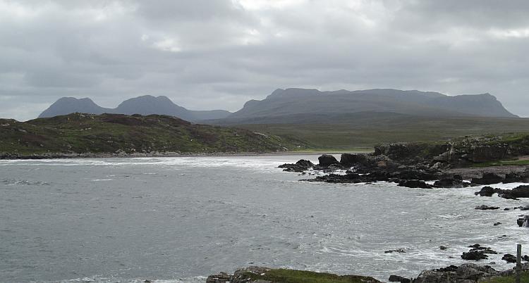 a remote sandy beach among rock, mountains and the seas