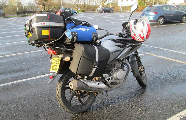 Ren's Honda CBF 125 all loaded up with camping gear on a car park