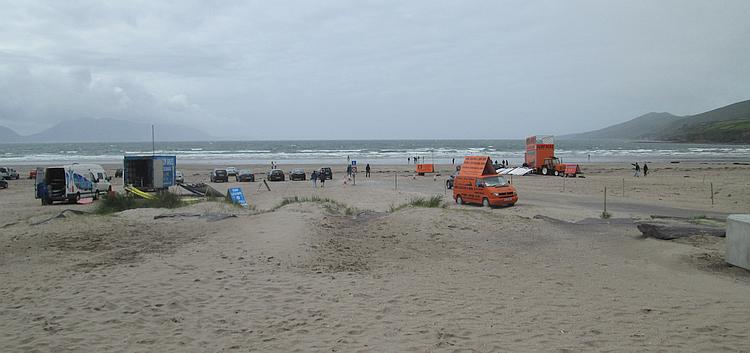 Inch beach with mobile surfing school vans and some surfers in the sea