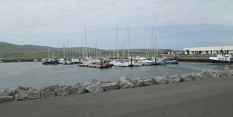 Dingle harbour with sailing boats and hills in the background
