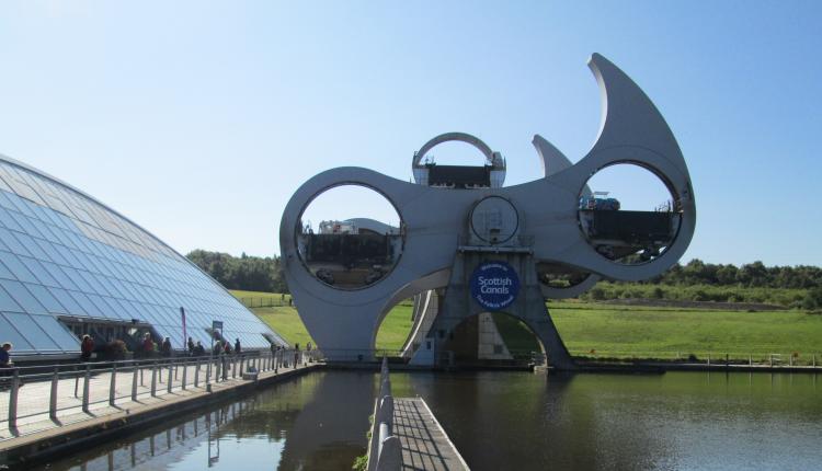 the large falkirk wheel in mid turn. nest to is is a large shing glass building,