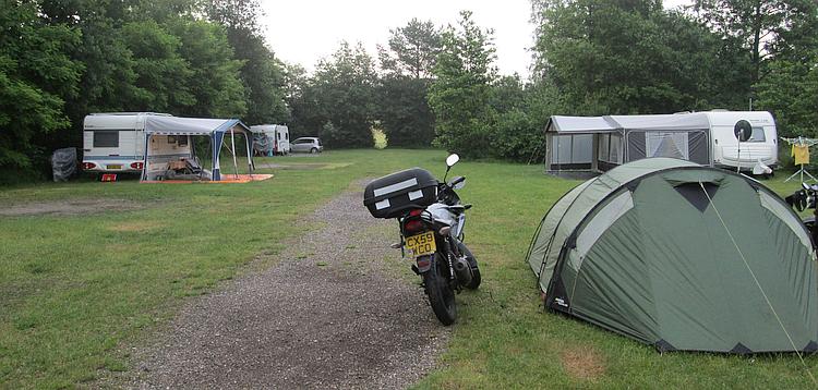 The tent and the 125cc motorcycles at the campsite, with caravans near by