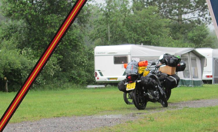 2 very wet motorcycles, it's raining so hard you can see the streaks of water