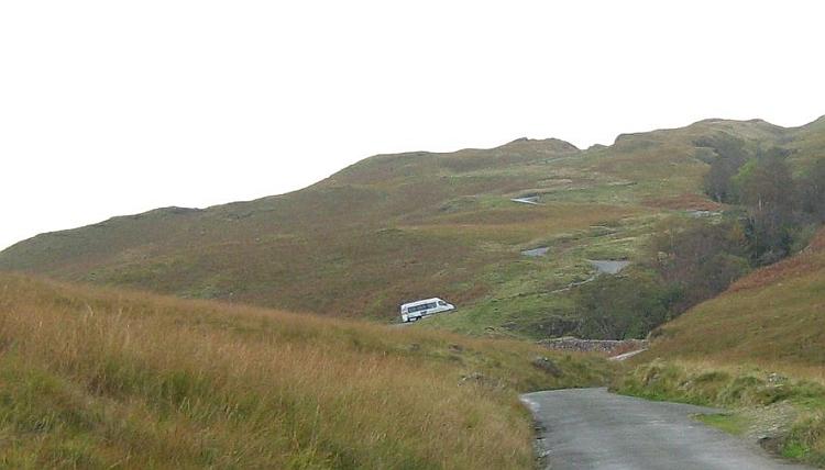 A van crawls up a steep twisty road on The Hardknott Pass