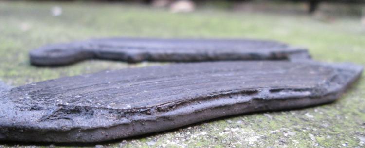 A pair of very worn out, almost to the metal, brake pads