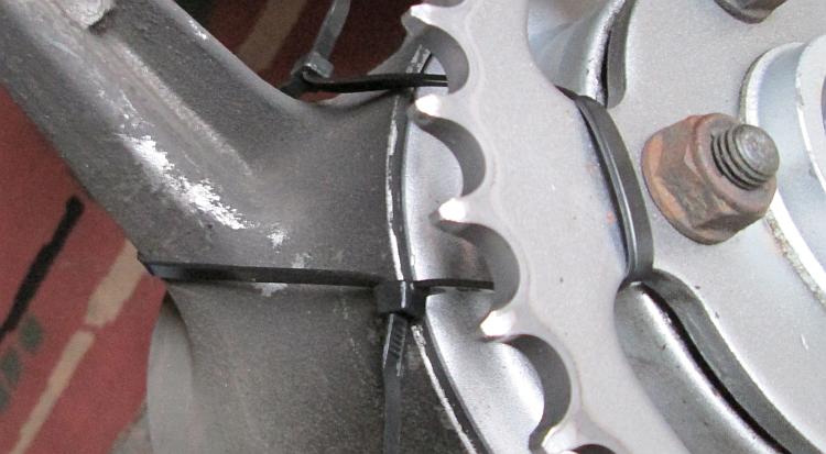 The zip tie can be seen though the sprocket and around one of the spokes