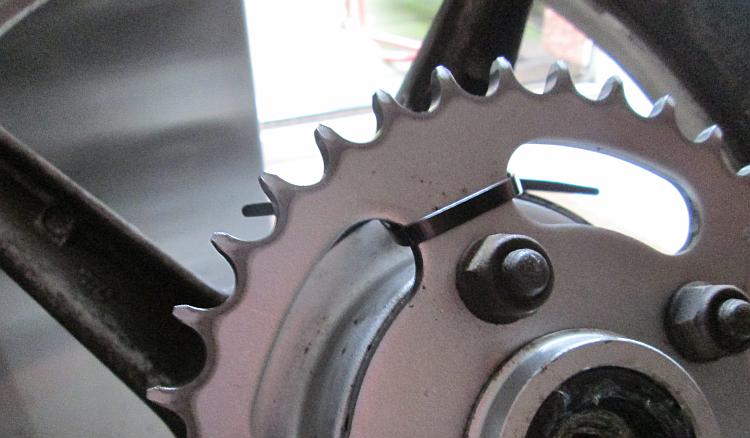 A zip tie through the sprocket of a motorcycle rear wheel