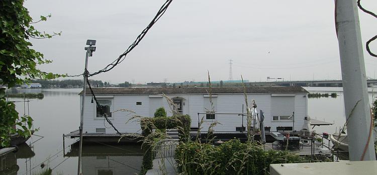 What looks like a static caravan on a pontoon, a dutch boat house