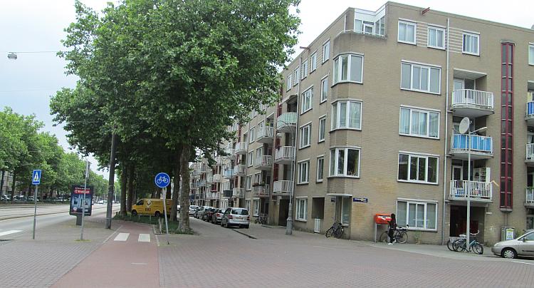 A wide street and a big block of flats in the suburbs. Not pretty, but clean.