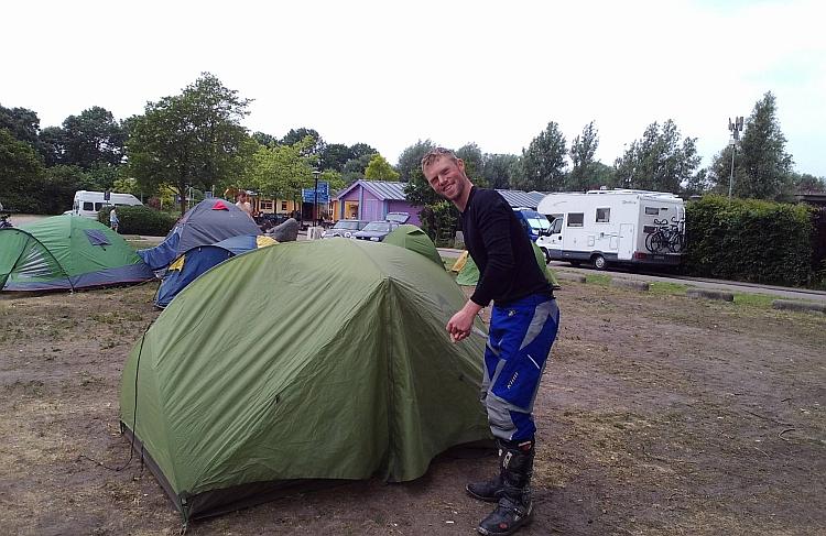 David finishes putting up his tent with a smile