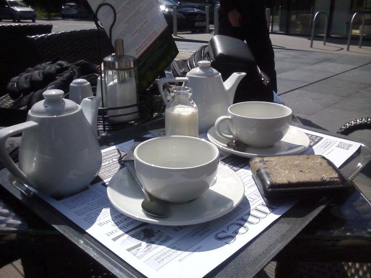 Modern white posh tea pots and cups in the sunshine at a cafe in the Lakes