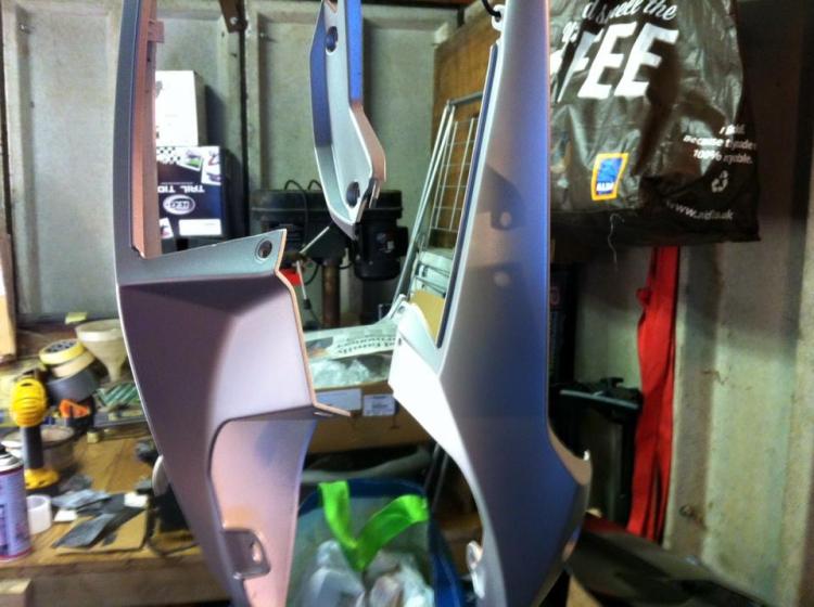 The rear panels in a matt grey primer hanging from the garage roof