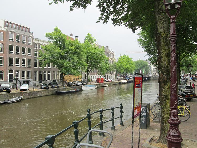 tall houses, canals, bicycles and boats, the scene of a street in Amsterdam