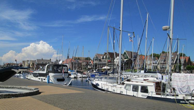 Blue skies, yachts and sailing boats, dutch houses and a smart clean harbour in Urk