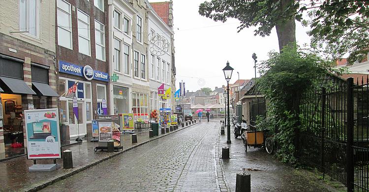 A boots chemist and various other shops along a very wet street in Zierikzee
