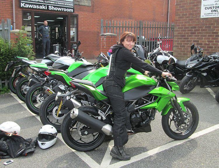 Sharon is smiling as she sits on the new Z250SL outside the shop