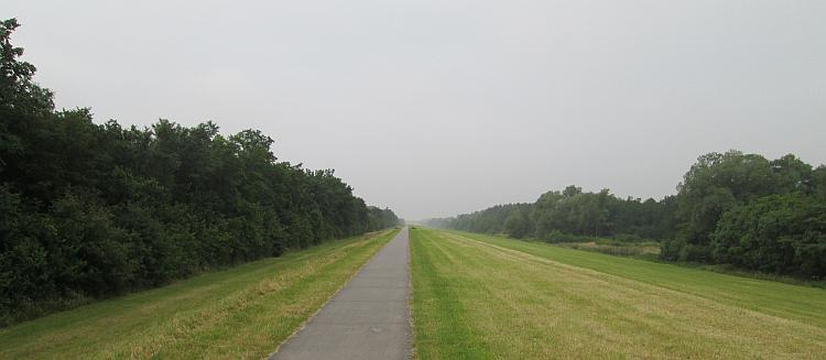 A long straight path runs into the distance on a long dutch dyke