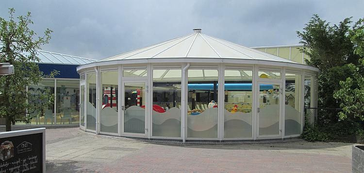 A large UPVC and glass structure covers the swimming pool in the sun