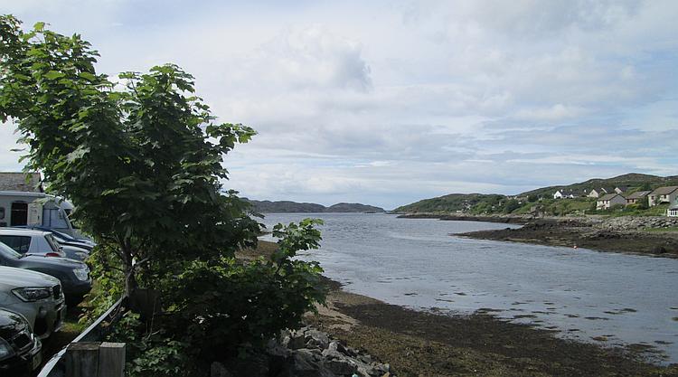Loch Inver seen from Lochinver town. A small town sloping down to the sea loch